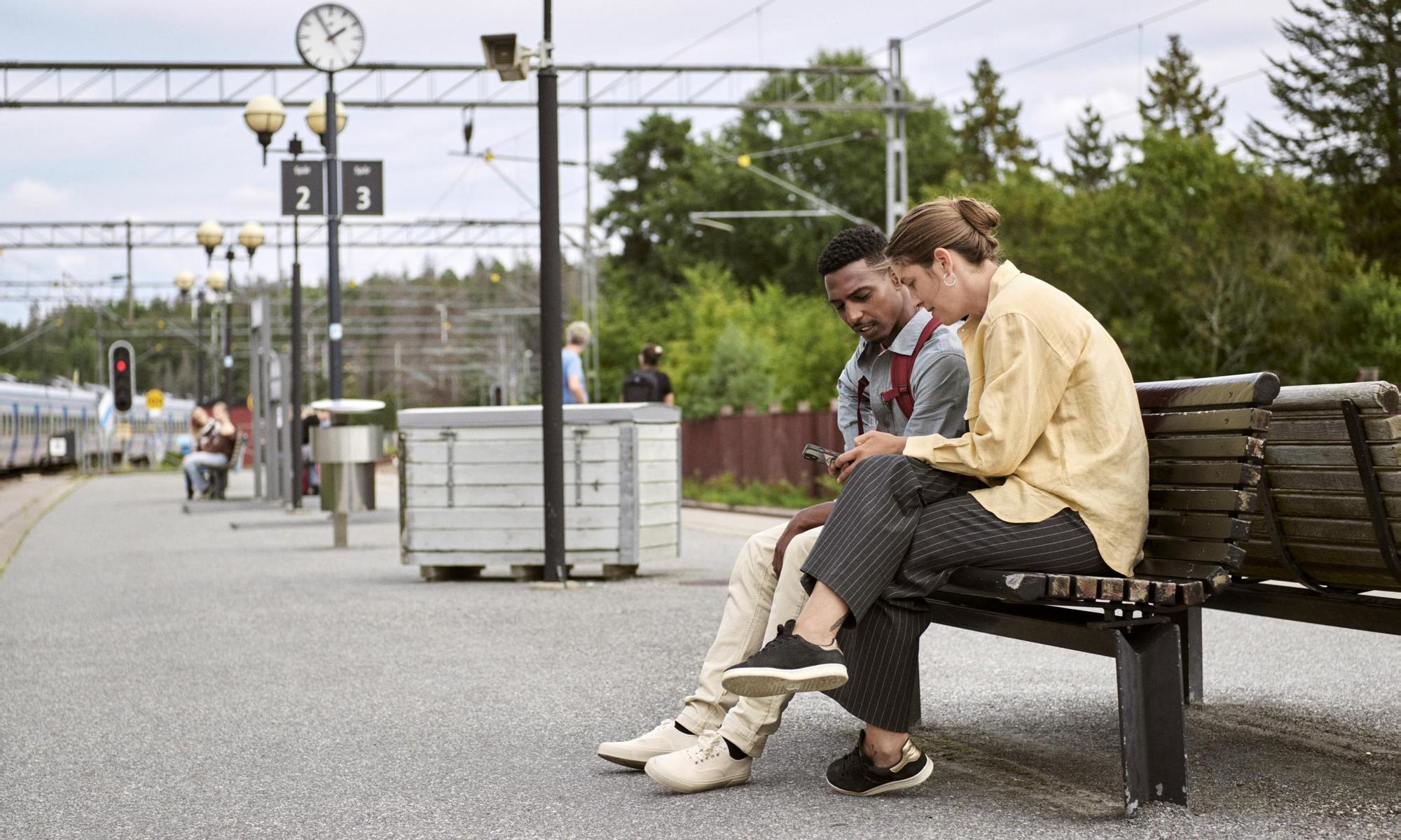 Couple sitting on a bench waiting for the train