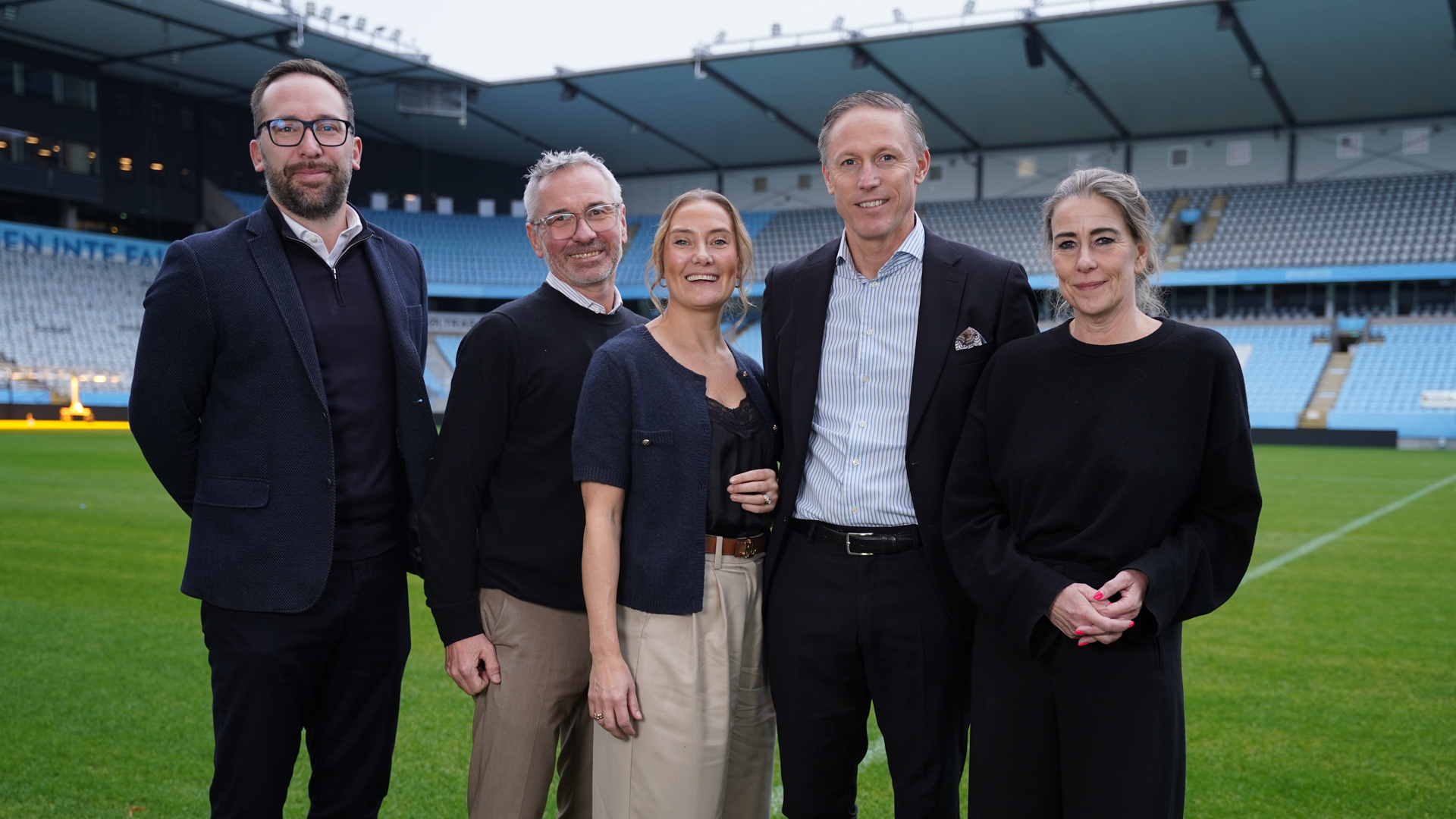 Tre män och två kvinnor på Malmö FFs hemmaarena Eleda Stadion. 