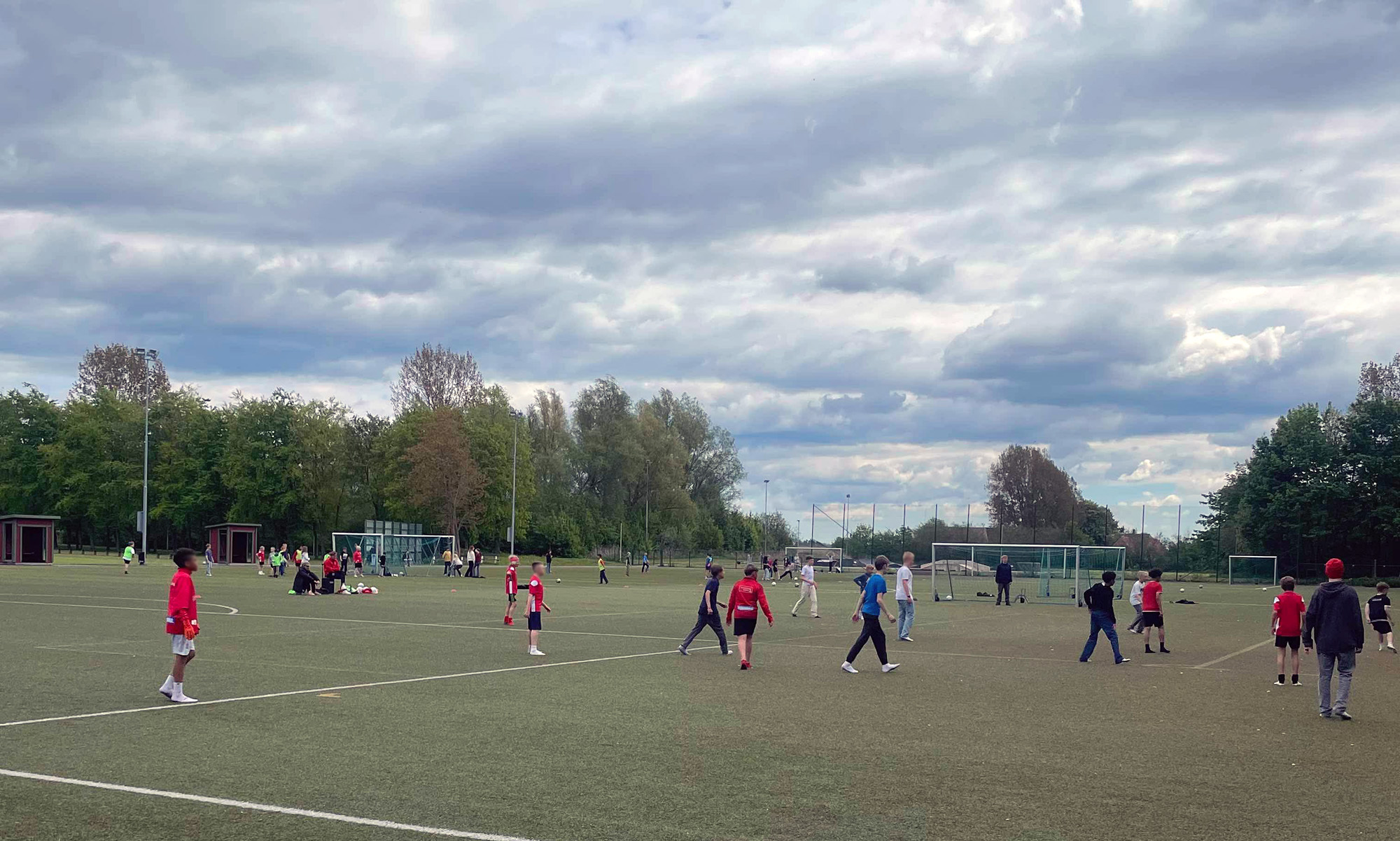 Barn spelar fotboll på en fotbollsplan.