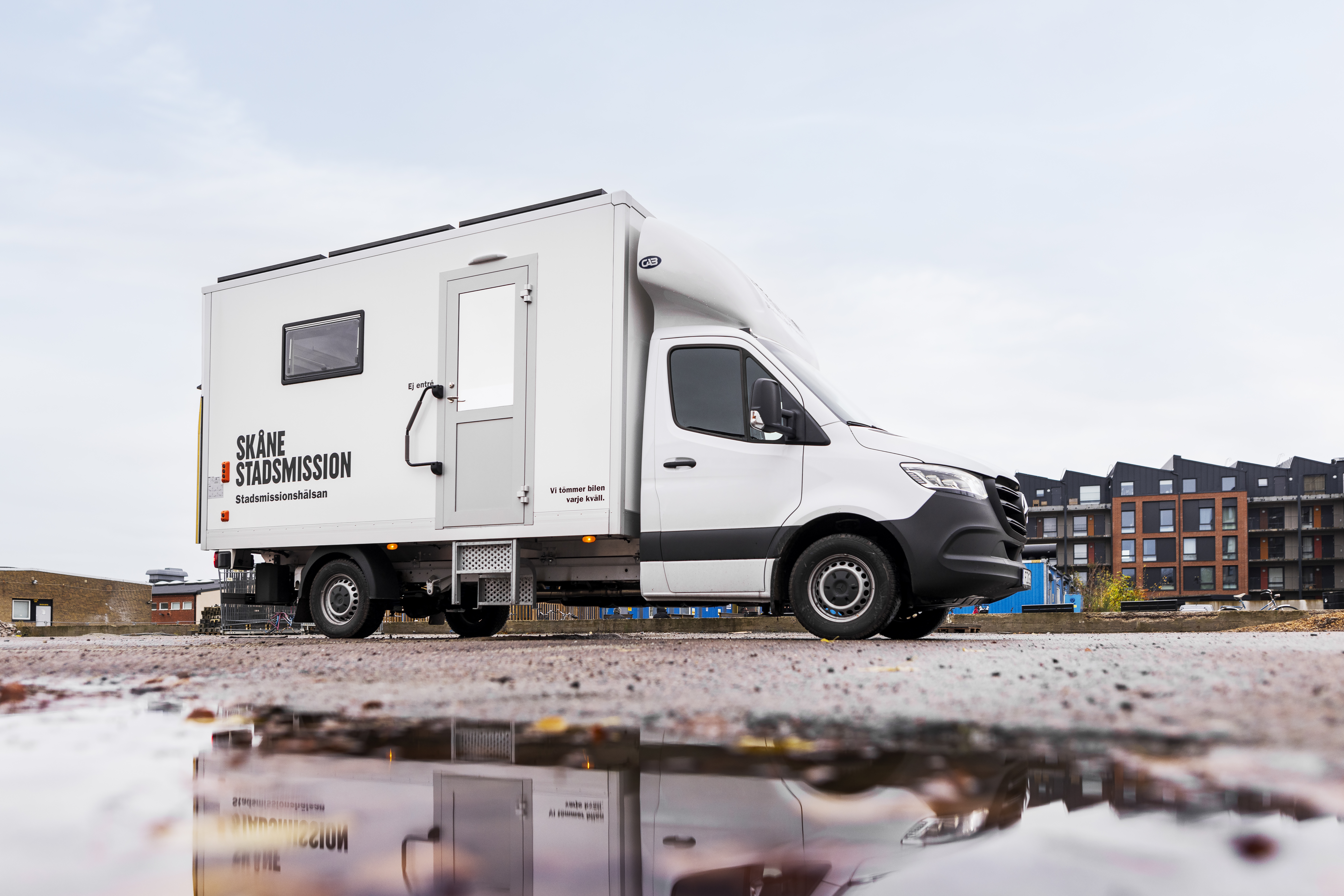 En lastbil står parkerad vid en vattenpöl.