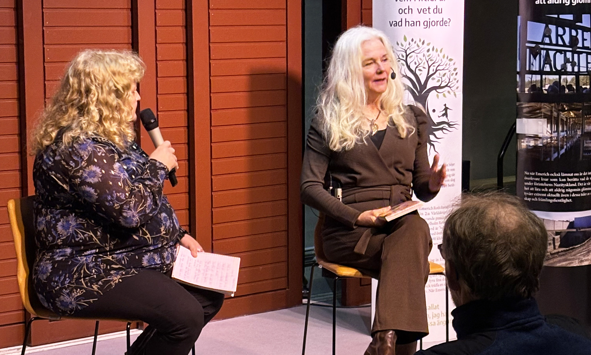 Två kvinnor på en scen sitter och har ett samtal. 